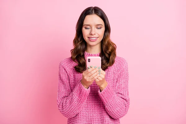 Retrato de chica atractiva alegre enfocada de pelo ondulado utilizando dispositivo de navegación aislado sobre fondo de color pastel rosa —  Fotos de Stock