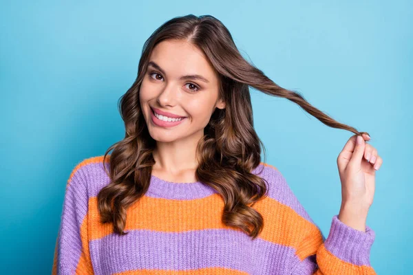 Foto de encantadora dama coqueta jugar rizo mirada cámara brillante sonrisa blanca usar suéter de rayas aislado fondo azul —  Fotos de Stock