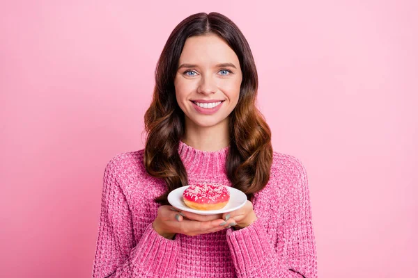 Photo of optimistic nice brunette lady hold donut wear pink sweater isolated on pastel pink color background — Stock Photo, Image