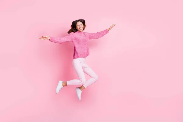 Teljes méretű profil fotó optimista hűvös barna hölgy ugrás viselni rózsaszín pulóver nadrág cipő elszigetelt rózsaszín háttér — Stock Fotó