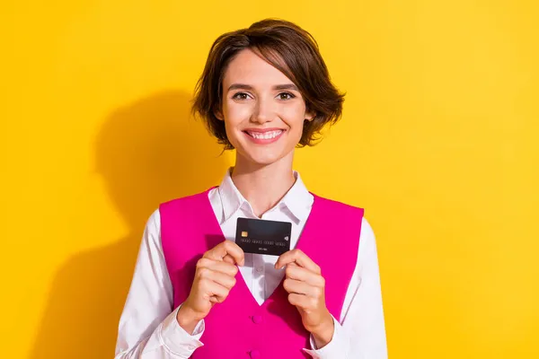 Foto de mulher bonita engraçada vestido terno rosa segurando cartão de crédito sorrindo isolado fundo cor amarela — Fotografia de Stock