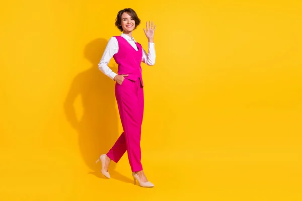 Plná délka tělo velikost pohled na atraktivní veselý businesswoman jít mává hi izolované přes jasně žluté barvy pozadí — Stock fotografie