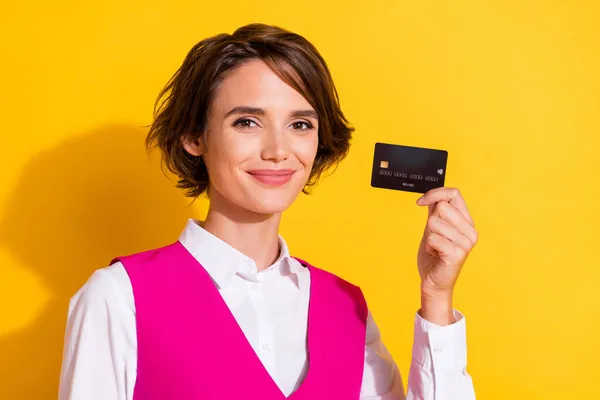 Foto de bonito encantador jovem senhora desgaste rosa terno sorrindo segurando cartão de banco isolado cor amarela fundo — Fotografia de Stock