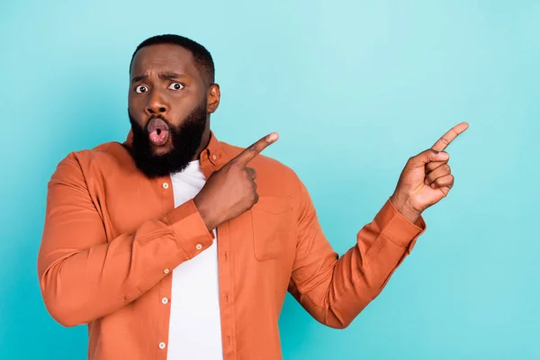 Foto von jungen schwarzen Mann erstaunt schockiert Zeigefinger leeren Raum Werbung Promo isoliert über türkisfarbenen Hintergrund — Stockfoto
