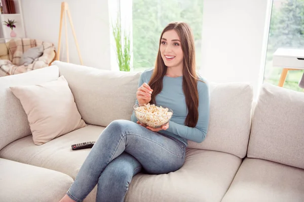 Фото позитивной рад любопытный довольно милая девушка держать чашу попкорн смотреть серии носить голубую рубашку дома в помещении — стоковое фото