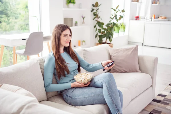 Profile side photo of young attractive woman happy positive smile switch channel remote controller television popcorn indoors — Stock Photo, Image
