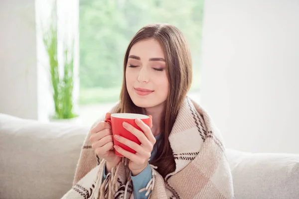 Foto portret jonge vrouw drinken hete thee in geruite deken thuis — Stockfoto