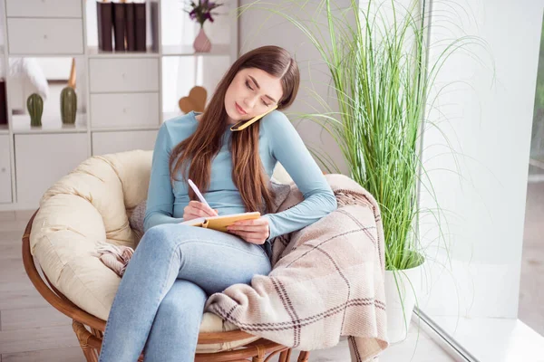 Fotografia młody atrakcyjny biznes kobieta mówić mówić słuchać telefon robić notatki odległość praca siedzieć kanapa dom — Zdjęcie stockowe