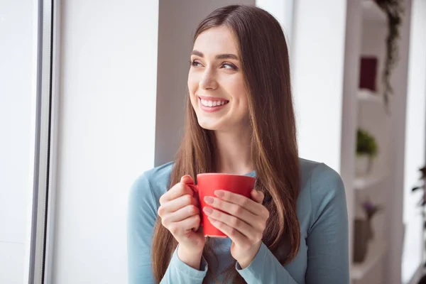 Profilo foto laterale di giovane ragazza allegra felice sorriso positivo bere tazza di caffè tè mattina guardare finestra sognante al chiuso — Foto Stock