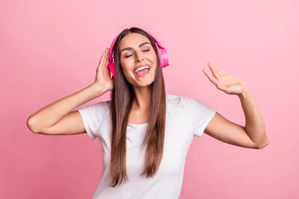 Retrato de atractiva chica alegre soñadora escuchando solo baile aislado sobre fondo de color pastel rosa — Foto de Stock