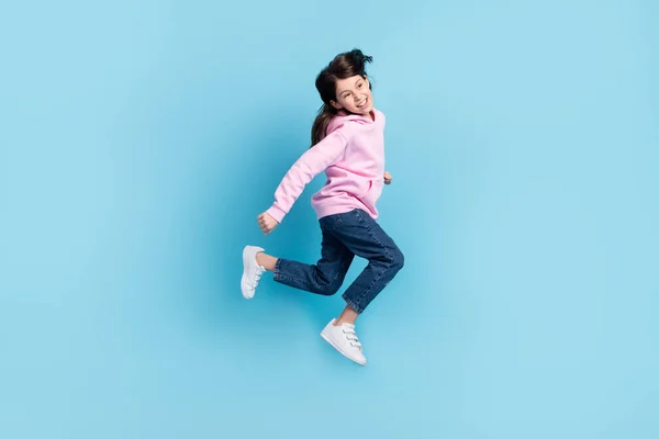 Comprimento total perfil de tamanho do corpo vista lateral da menina muito alegre pulando se divertindo isolado sobre fundo de cor azul brilhante — Fotografia de Stock