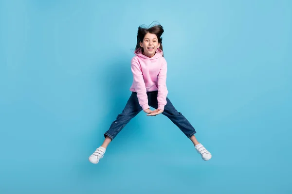 여자 점프 점프의 전체 사진은 파란 배경에 고립된 스웨트 셔츠 청바지 신발을 착용하고 있다 — 스톡 사진