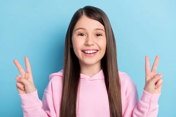 Foto van jonge tiener meisje gelukkig positieve glimlach tonen vrede cool v-teken geïsoleerd over blauwe kleur achtergrond — Stockfoto