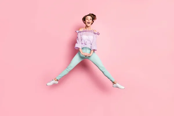 Portrait photo pleine longueur de fille mignonne excitée sautant isolé sur fond rose pastel — Photo
