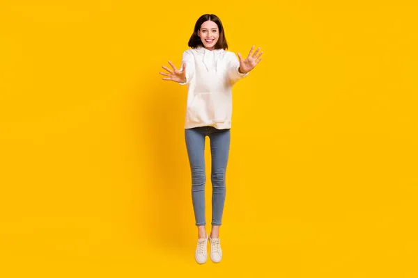 Foto van grappige energieke dame spring golf palm dragen witte hoodie jeans schoenen geïsoleerde gele kleur achtergrond — Stockfoto
