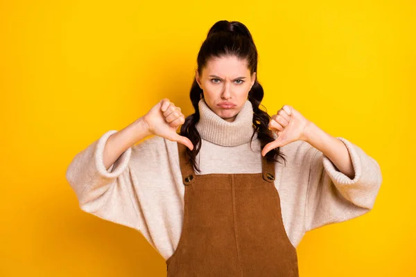 Portret van aantrekkelijke trendy chagrijnige ontevreden meisje tonen duim naar beneden symbool reactie geïsoleerd over helder gele kleur achtergrond — Stockfoto