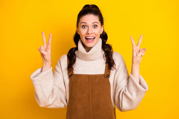 Портрет привабливої здивованої веселої дівчини, що показує подвійний v-знак, розважається ізольовано на яскравому жовтому кольоровому фоні — стокове фото