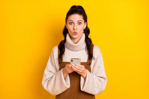 Portret van aantrekkelijke grappige verbaasd meisje met behulp van gadget browsen media pruik lippen geïsoleerd over helder gele kleur achtergrond — Stockfoto