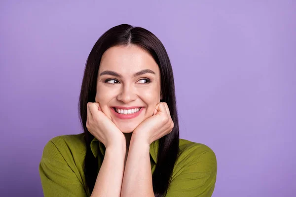 Photo of excited sweet young lady dressed green clothes smiling arms cheekbones looking empty space isolated purple color background — Stock Photo, Image