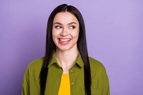 Photo of funny tricky young lady dressed green clothes smiling licking lips looking empty space isolated purple color background — Stock Photo, Image