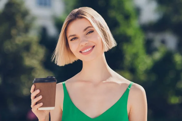 Photo of dreamy cute young lady wear green outfit smiling walking enjoying tasty tea outside urban city street — Stock Photo, Image