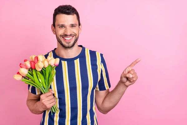 Photo portrait man keeping tulips bouquet showing copyspace isolated pastel pink color background — Stock Photo, Image