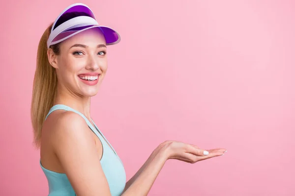Profil côté photo de jeune fille attrayante heureux sourire positif tenir la main produit promo isolé sur fond de couleur rose — Photo