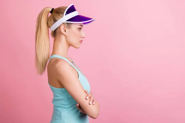 Foto de perfil de la cola seria peinado milenial dama deportiva cruzada brazos mirada desgaste sombrero superior de color turquesa aislado sobre fondo de color rosa — Foto de Stock