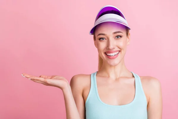 Portrait of attractive cheerful girl holding on palm demonstrating copy space offer solution isolated over pink pastel color background — Stock Photo, Image