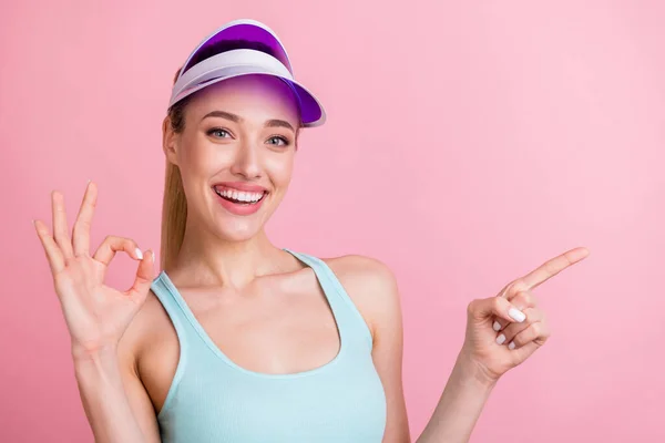 Portrait of attractive cheerful girlish girl showing ok-sign demonstrating copy space isolated over pink pastel color background — Stock Photo, Image