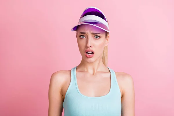 悲伤的金发年轻的女运动员戴帽子头戴绿松石顶，背景为粉色，照片中的她是一位年轻的女运动员 — 图库照片