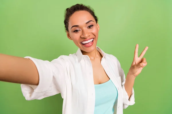 Foto ritratto donna con panino acconciatura mostrando v-segno prendendo selfie isolato colore verde pastello sfondo — Foto Stock