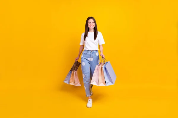 Full size foto van gelukkig glimlachen mooi vrolijk meisje gaan winkelen shopaholic geïsoleerd op gele kleur achtergrond — Stockfoto