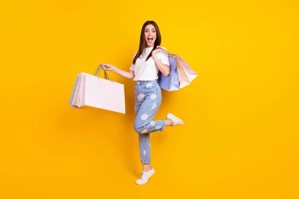 Foto em tamanho completo de feliz animado louco espantado mulher shopaholic segurar sacos de compras isolados no fundo de cor amarela — Fotografia de Stock