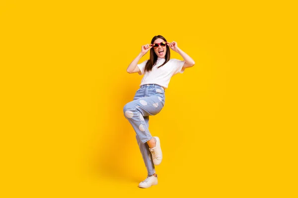 Foto de corpo inteiro de menina animada feliz sorriso positivo hipster mãos toque de vidro solar isolado sobre fundo de cor amarela — Fotografia de Stock