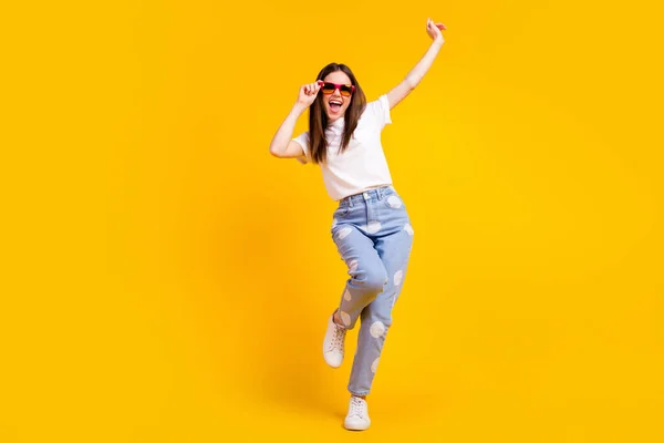 Foto tubuh penuh gadis muda bersemangat tersenyum positif hipster tangan menyentuh kacamata terisolasi dengan latar belakang warna kuning — Stok Foto
