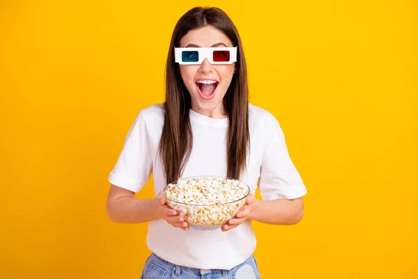 Photo of young excited girl happy positive smile wear 3d glasses watch comedy eat popcorn isolated over yellow color background — Stockfoto