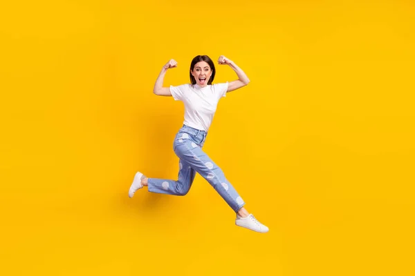 Perfil de comprimento total foto lateral da menina feliz sorriso positivo saltar para cima ir executar mostrar músculos isolados sobre fundo de cor amarela — Fotografia de Stock