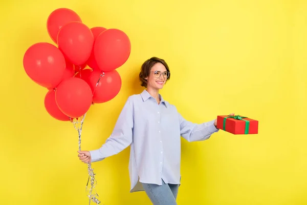 Fotografie mladé ženy šťastný pozitivní úsměv host dovolená narozeniny mnoho míč dárek izolované přes žluté barvy pozadí — Stock fotografie