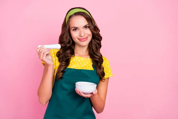 Foto di affascinante sognante giovane signora vestita grembiule verde sorridente spezie cucina isolato colore rosa sfondo — Foto Stock