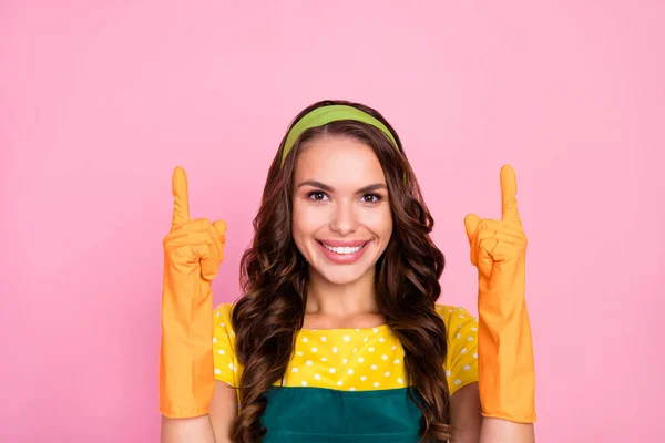 Photo of shiny pretty young woman wear green apron rubber gloves smiling pointing fingers empty space isolated pink color background — Foto Stock