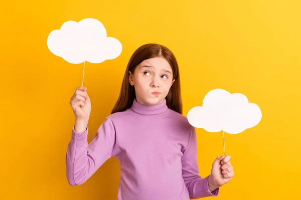 Φωτογραφία από αβέβαιο αβέβαιο αμφίβολο στοχαστικό κοριτσάκι κρατήσει σύννεφα χαρτί ματιά copyspace απομονώνονται σε κίτρινο χρώμα φόντο — Φωτογραφία Αρχείου