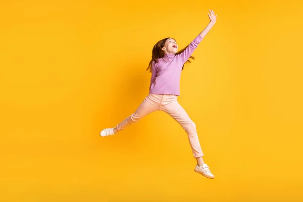 신나고 명랑 한 작은 소녀 점프의 완전 한 크기 사진 노란색 배경에 분리 된 복사 공간처럼 보인다 — 스톡 사진