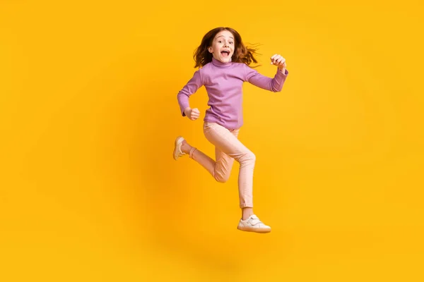 밝은 노란색 배경 위로 분리 된 활달 한 소녀가 뛰어오르는 매력적 인 모습의 전체 몸길이 — 스톡 사진