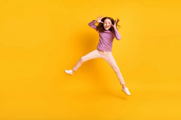 Foto de tamaño completo de funky divertida niña graciosa saltando tonteando mostrando lengua aislada en el fondo de color amarillo —  Fotos de Stock