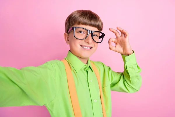 Фотографія молодого хлопчика шкільного віку відео-шоу добре, добре, символ угоди вибрати оголошення ізольовані на фоні рожевого кольору — стокове фото