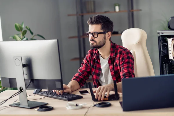 Portret van aantrekkelijke bekwame trendy gerichte man instellen wifi router web wlan schrijven code op kantoor werkplek station indoor — Stockfoto