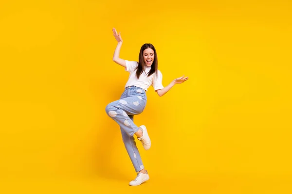 밝은 미소를 짓고 있는 젊고 흥분 한 소녀의 완전 한 크기 사진은 노란 배경 위에 따로 떨어져 즐거운 댄스 파티를 즐긴다 — 스톡 사진