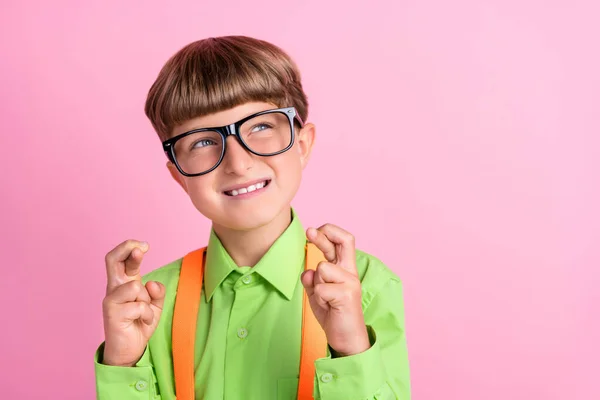 Foto av unga skolan pojke korsade fingrar hängivenhet förväntar examen önskar framgång isolerad över rosa färg bakgrund — Stockfoto