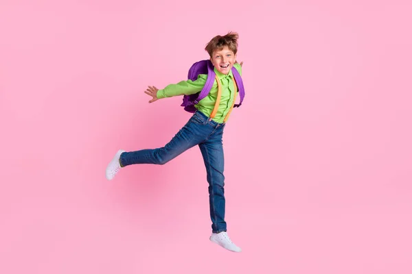 Вид в полный рост на красивого трехлетнего мальчика, прыгающего весело на розовом фоне — стоковое фото
